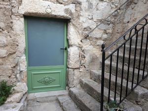 a blue door on a stone building with stairs at LA GARDE ADHEMAR, L'escalier Médiéval in La Garde-Adhémar
