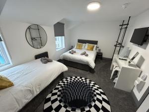 um quarto com 2 camas e um espelho em The White House New York Suites em Blackpool