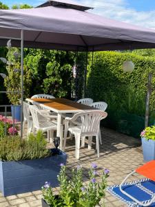 a table and chairs under an umbrella on a patio at Balaton Soul House in Vonyarcvashegy