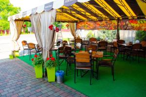 a restaurant with tables and chairs under a tent at Hotel VIZA in Solotvyno