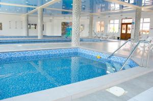 a swimming pool with blue water in a building at Hotel VIZA in Solotvyno