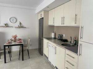 a kitchen with a table and a sink and a refrigerator at Apartamento Calpe in Calpe