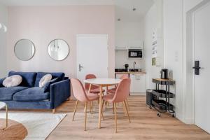 a living room with a blue couch and a table and chairs at Magnifique appartement Blush refait à neuf in Saint-Étienne