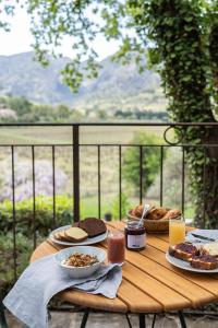 uma mesa de madeira com comida em cima de uma varanda em La Bastide du Mourre em Oppède