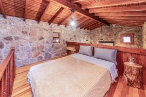 a bedroom with a bed and a stone wall at Chic Villa w Fireplace 3 min to Beach in Bodrum in Bitez
