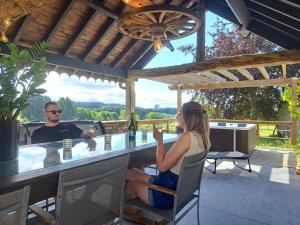 a man and a woman sitting at a bar at Gîte Les 3 pierres in Houffalize