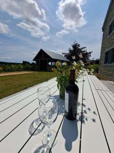Una botella de vino y dos copas en una mesa. en Gîte Les 3 pierres, en Houffalize