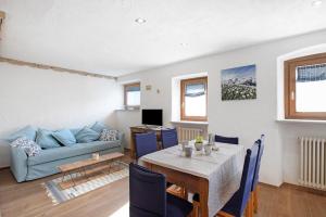 ein Wohnzimmer mit einem Tisch und einem blauen Sofa in der Unterkunft Souvenir au Moulin in Aymavilles
