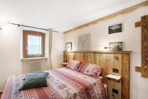 a bedroom with a bed with a wooden headboard at Souvenir au Moulin in Aymavilles