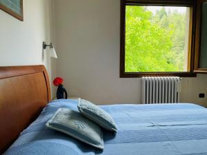 una camera da letto con un letto con lenzuola blu e una finestra di Appartamento Europa a Fanano