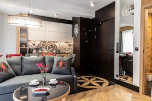 a living room with a blue couch and a table at Modrzejewska Residence Zakopane in Zakopane