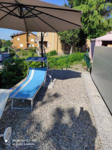 parco giochi con scivolo blu e ombrellone di Appartamento con piscina e giardino a Tolè