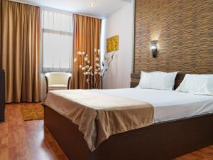 A bed or beds in a room at Guci Hotel