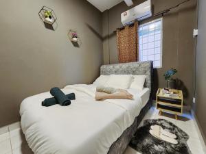 una camera da letto con un letto con lenzuola bianche e una finestra di Shah Alam U8 FULLY AIR-CON Suite a Shah Alam