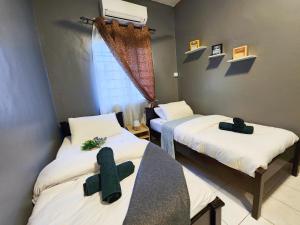 Shah Alam U8 FULLY AIR-CON Suite في شاه عالم: غرفة بسريرين عليها صليب