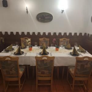 een tafel in een restaurant met een witte tafelkleed bij Gostilna in apartmaji Zlati lev - Maribor in Maribor