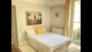 a bedroom with a bed with a yellow pillow on it at Central Truro! Large Double Room In Victorian Property in Truro