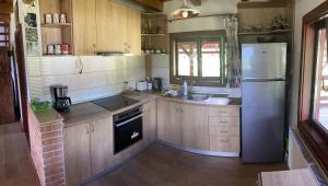 a kitchen with wooden cabinets and a refrigerator at Cabana Transilvania in Beliş