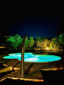 uma piscina à noite com uma fonte de água em Agriturismo Podere Valdo em Gavorrano