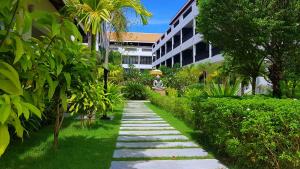 einen Garten mit einem Steinweg vor einem Gebäude in der Unterkunft New Riverside Hotel in Siem Reap