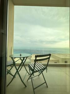 krzesło i stół na balkonie z widokiem w obiekcie Le bellevue apartment w mieście Llogara