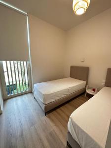 sypialnia z 2 łóżkami i dużym oknem w obiekcie Le bellevue apartment w mieście Llogara
