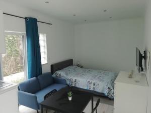 sala de estar con sofá azul y mesa en Refúgio Aconchegante, en Nadadouro