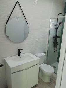 y baño con lavabo, aseo y espejo. en Refúgio Aconchegante, en Nadadouro