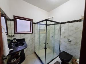 y baño con ducha acristalada y lavamanos. en Casa da Dilma Trancoso, en Trancoso