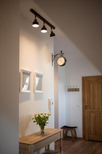 a room with a table and a clock on the wall at Narnia Apartment in Toruń +26 photos
