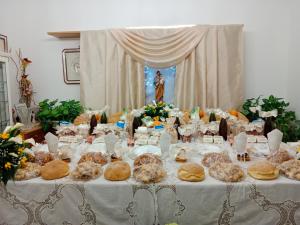 una mesa con un mantel blanco con comida. en Vianova Affittacamere en Giurdignano