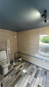 ein Bad mit einem WC, einem Waschbecken und einem Fenster in der Unterkunft Hébergement au bord de l'eau 