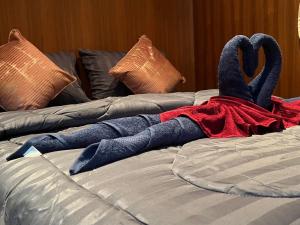 a stuffed bird is laying on a bed at SK Hometel Samui Airport in Bang Rak Beach