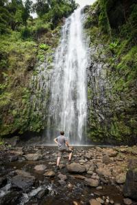 a man standing in front of a waterfall at Kilimanjaro Mountain View Campsite 