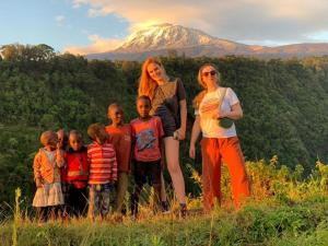 a group of children standing in front of a mountain at Kilimanjaro Mountain View Campsite 