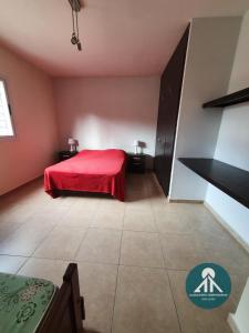a bedroom with a red bed in a room at Complejo Temporario Las Marias in San Juan