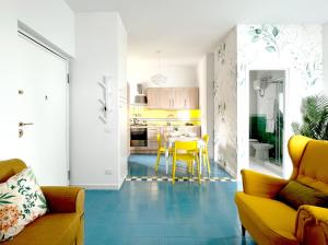 sala de estar con sillas amarillas y cocina en Casa Mirabella, en Scalea