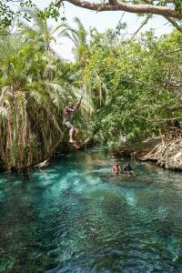 a group of people on a rope swing in a river at Kilimanjaro Mountain View Campsite 