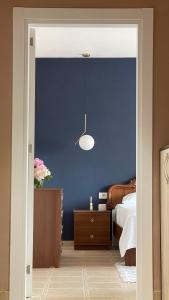 1 dormitorio con pared azul, cama y mesa en Leo’s apartment, en Shkodër