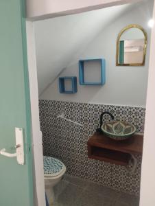 een badkamer met een toilet, een wastafel en een spiegel bij Andalusisches Altstadt-Haus Estepona in Estepona