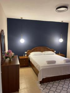 1 dormitorio con 1 cama grande y pared azul en Leo’s apartment, en Shkodër