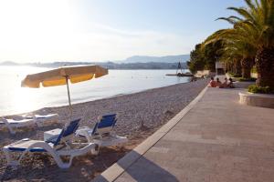 two chairs and an umbrella on a beach at Residence Apartments Anamaria in Podstrana