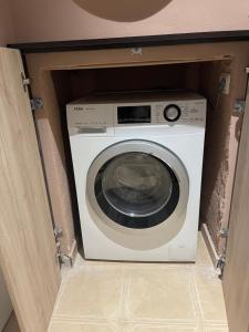 een wasmachine en droger in een kast in een kamer bij Leo’s apartment in Shkodër