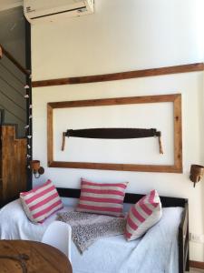 1 dormitorio con 1 cama con almohadas rosas y blancas en Finca La Escondida San Rafael en San Rafael