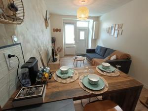 a living room with a table with plates on it at Joli cocon en hyper centre in Loudéac