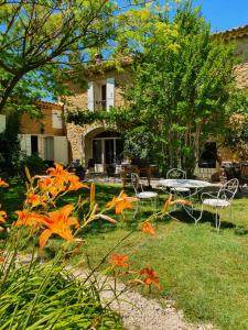 a garden with a table and chairs in front of a house at La Mandarine in Piolenc