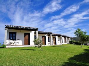 a small house with a green lawn in front of it at Sa Prata Hotel & Resort in Budoni
