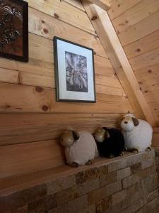 two stuffed sheep sitting on a wall with a picture at Vikendica GORSKI VUK Jelovica in Berane