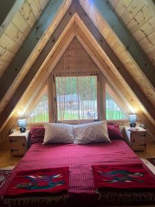 a bedroom with a large bed in a attic at Vikendica GORSKI VUK Jelovica in Berane