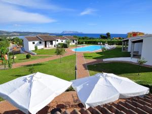 two white umbrellas on the roof of a house at Sa Prata Hotel & Resort in Budoni